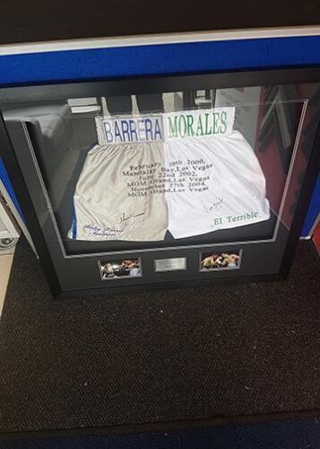 Framed boxing shorts with plaque and photographs